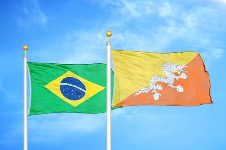 Brazil and Bhutan two flags on flagpoles and blue cloudy sky backgroundの写真素材