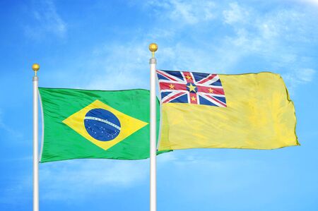 Brazil and Niue two flags on flagpoles and blue cloudy sky backgroundの写真素材