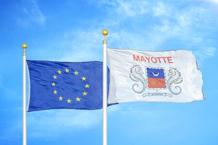 European Union and Mayotte two flags on flagpoles and blue cloudy sky backgroundの写真素材