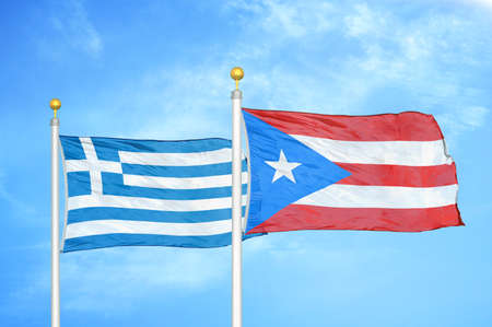 Greece and Puerto Rico two flags on flagpoles and blue cloudy sky background
