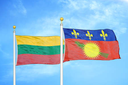 Lithuania and Guadeloupe two flags on flagpoles and blue cloudy sky background
