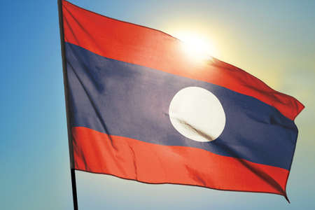 Laos flag waving on the wind in front of sunの写真素材