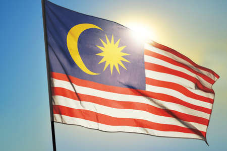 Malaysia flag waving on the wind in front of sunの写真素材
