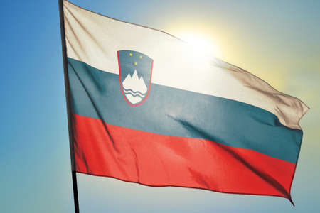 Slovenia flag waving on the wind in front of sunの写真素材