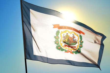 West Virginia state of United States flag waving on the wind in front of sun