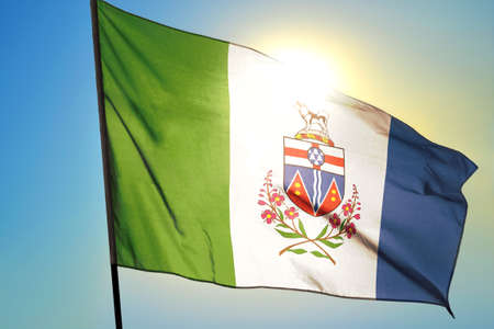 Yukon province of Canada flag waving on the wind in front of sunの写真素材