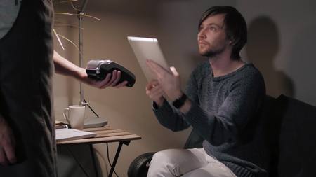 Paying with smartphone. Closeup of man making payment transaction with his mobile phoneの写真素材