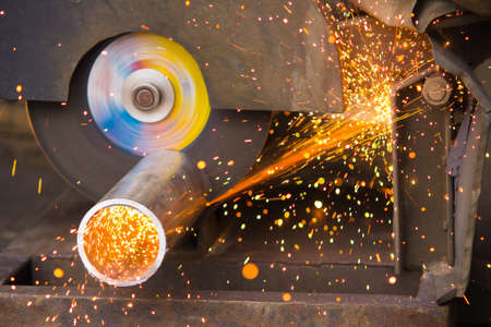Ð¡utting of a metal pipe with splashes of sparks