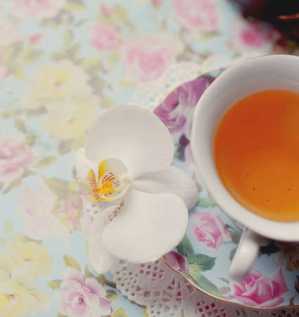 Color porcelain cup with tea and a saucerの写真素材