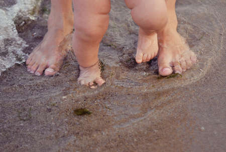 On sand in water a leg of the child 