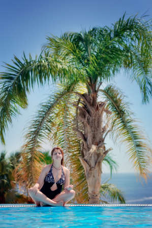 on lines of connection of the ocean and the pool the girl sitsの写真素材