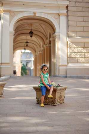 The boy in sunglasses and a cap looks in a distanceの写真素材