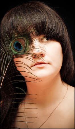 the girl with long hair and a pavliny eyeの写真素材