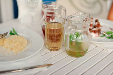 on a white cloth there are jugs with different drinksの写真素材