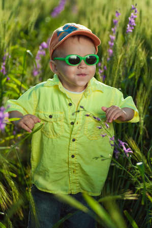 the child walks across the field in sunglassesの写真素材