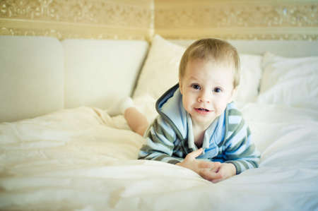 the child in a pajamas on a bed liesの写真素材