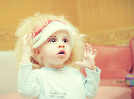 the kid in a wig and with cosmetics on a faceの写真素材