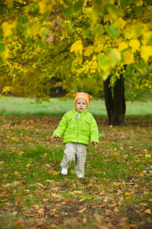 against green bushes the kid in a sweater and a capの写真素材