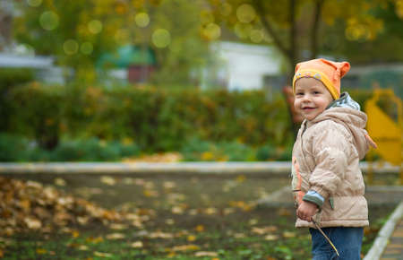against green bushes the kid in a sweater and a capの写真素材