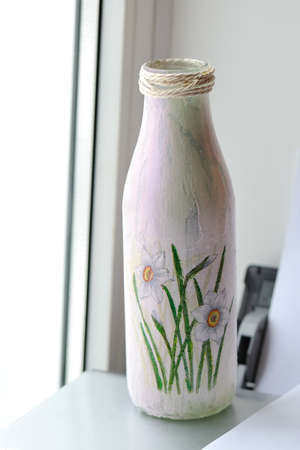 close up there is a white bottle with drawing of flowersの写真素材