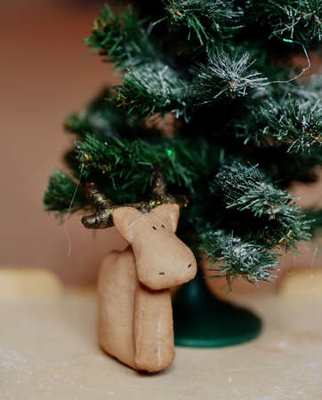 handwork of a brown deer under a green fir-treeの写真素材