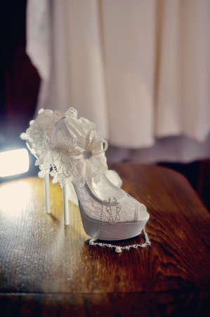 on the wooden floor are white shoes for the bride with dressingの写真素材