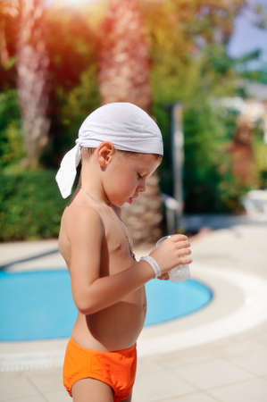 Pool with blue water is the boy in the orange trunksの写真素材