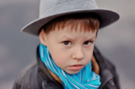 portrait of a boy in an elegant gray hat and blue scarfの写真素材