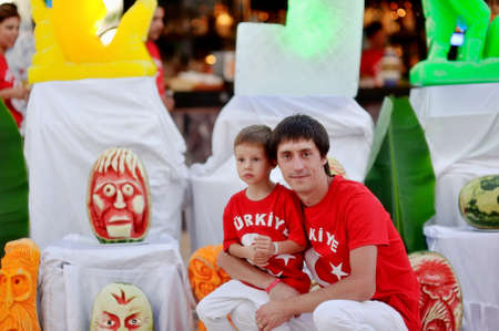 family sitting on white chairs among the sculptures of watermelonsの写真素材