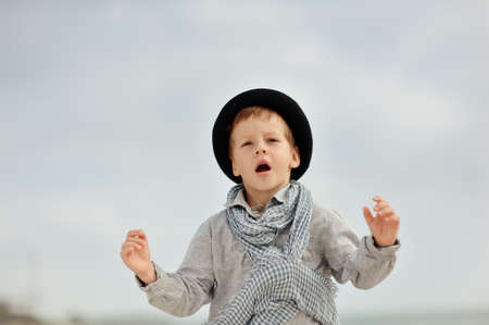 emotional boy in black hat and jeans posing on the beachの写真素材