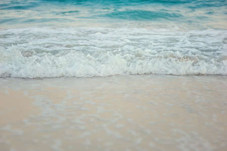 reel aqua with white foam on the sandの写真素材