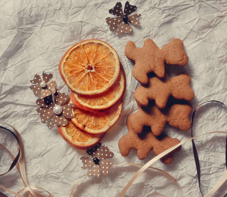 On a white table are dried orange segments and Christmas cookiesの写真素材