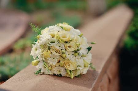 on the stone fence  a bouquet of white roses for the brideの写真素材
