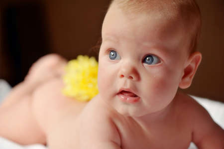 lays bare a beautiful baby with yellow flower on her back