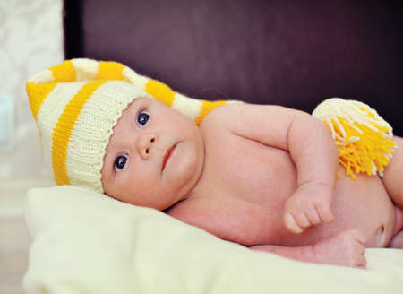 naked baby in a warm hat is in the suitcaseの写真素材