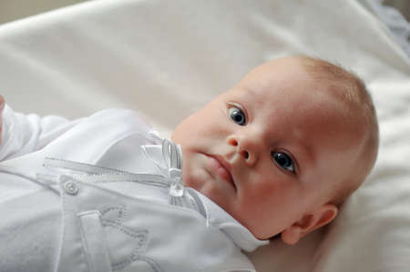 on a white background cute baby lying in a beautiful dressの写真素材