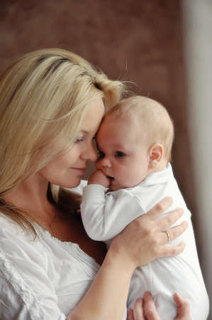 delicate and feminine mother tenderly embracing her childの写真素材