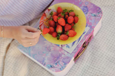 Red ripe strawberries lying on a yellow plateの写真素材