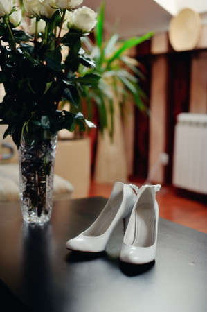 on the wooden floor are white shoes for the bride with dressingの写真素材