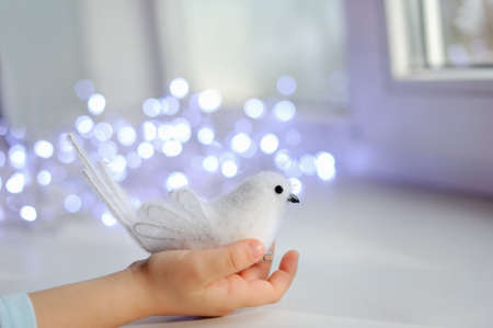 against the child s hand lights garland with white birdの写真素材