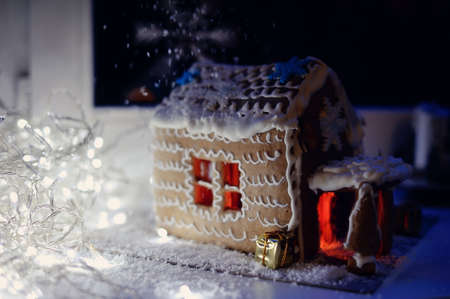 Christmas cake, a small house with snowflakes, and fire in the snowの写真素材