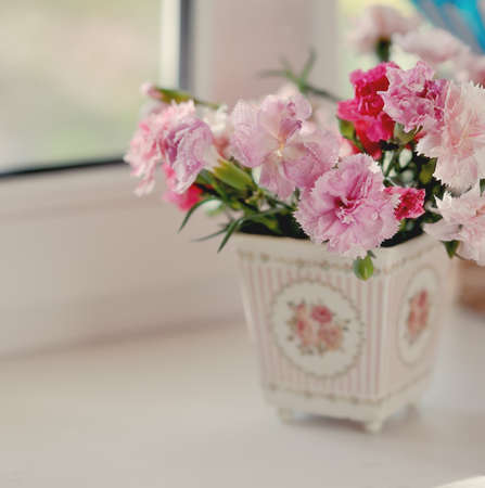 Beautiful fine bouquet of beautiful roses and carnations in a white potの写真素材