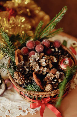 Christmas composition - a decorative candle and a basket with cones and grapesの写真素材