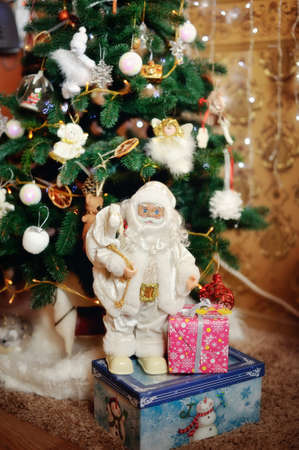 Under a beautiful New Year tree there is Santa Claus with giftsの写真素材