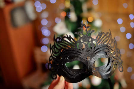 Close up a beautiful black New Year s mask against a fur-treeの写真素材