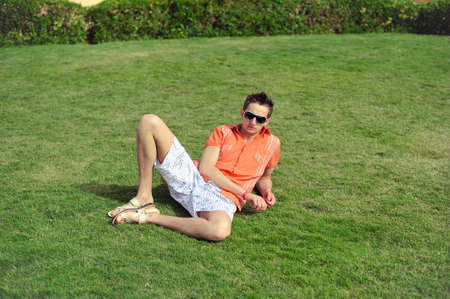On a green grass the guy in black sun glasses liesの写真素材