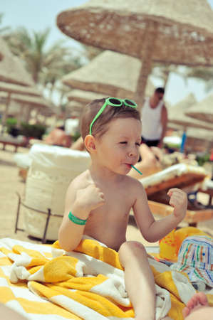 after bathing cheerful child sitting under a canopy in the towelの写真素材