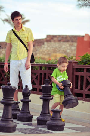 outside in the park Father and son playing with the big players in chessの写真素材
