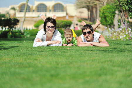 in the park on the green grass is a fun, happy familyの写真素材
