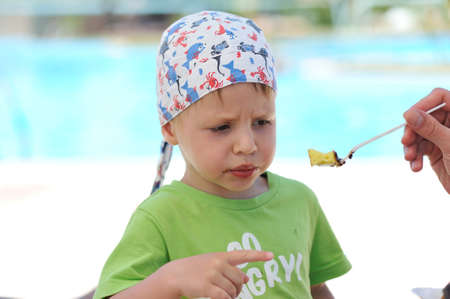 Father feeding son delicious dessert spoonの写真素材